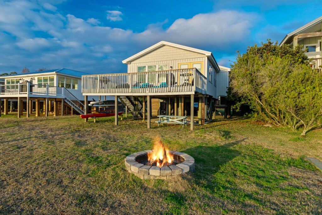 Backyard fire pit blazing under blue skies.