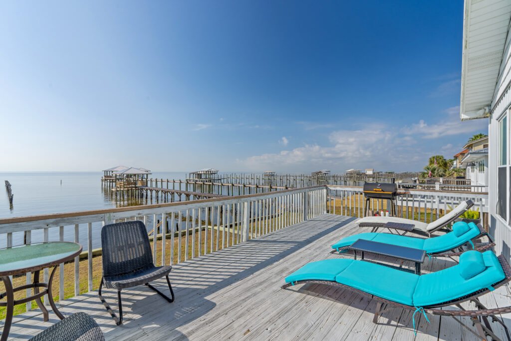 Sunbrella chairs are front row seats for blue skies and sunsets over Mobile Bay.