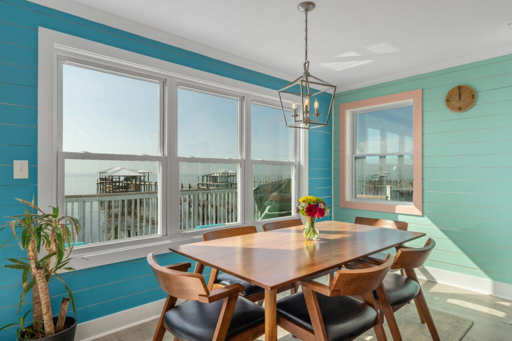 Triple window frames storybook sunsets over the water at from the dining table of this waterfront cottage,