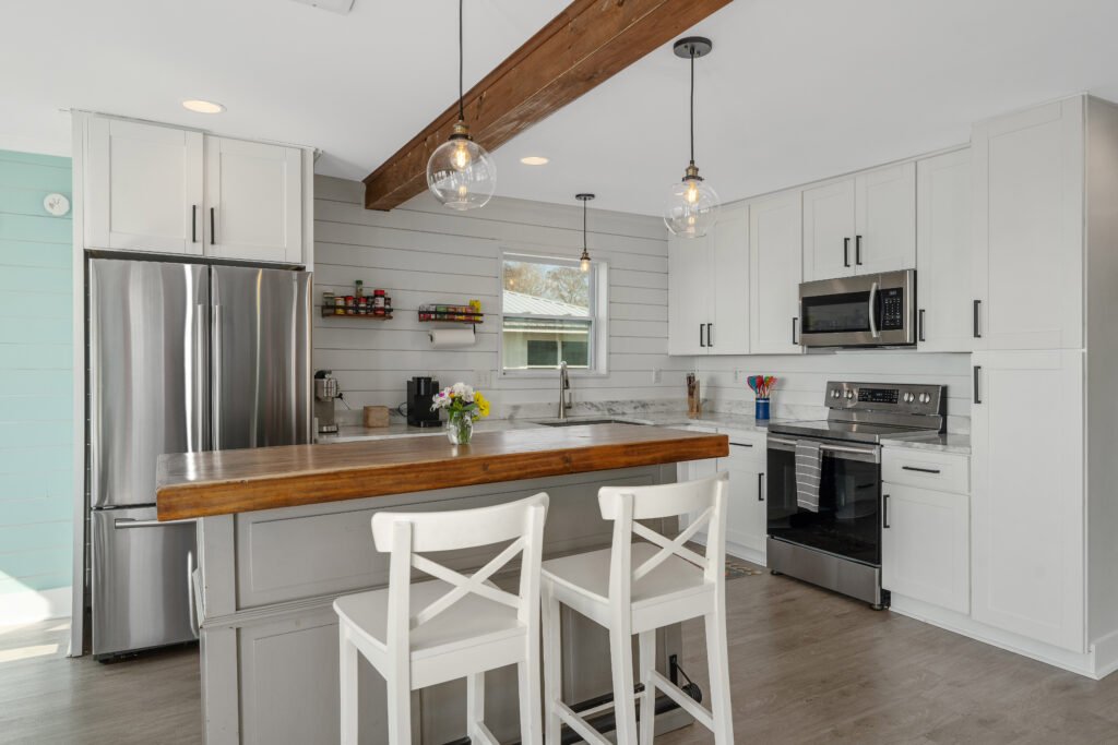 Floating island with bar stools helps to define kitchen area with additional utility.