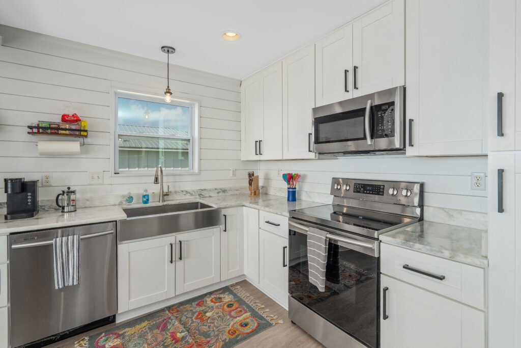 Marble countertops, stainless steel farmhouse sink, coffeemakers and microwave, range oven and dishwasher.