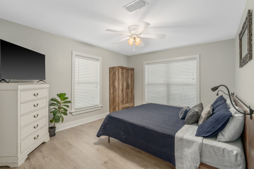 Master bedroom with king bed in modern walnut frame with reading lights.