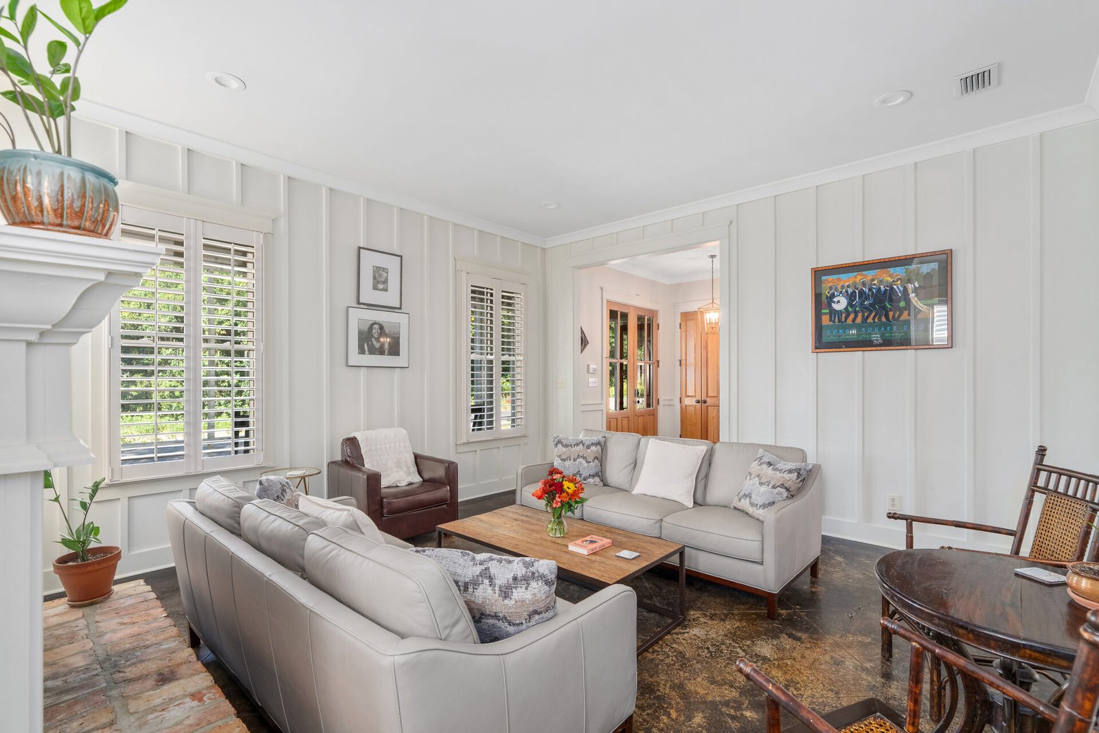 Spacious living room with leather sofas and artwork features bay house style batten walls.