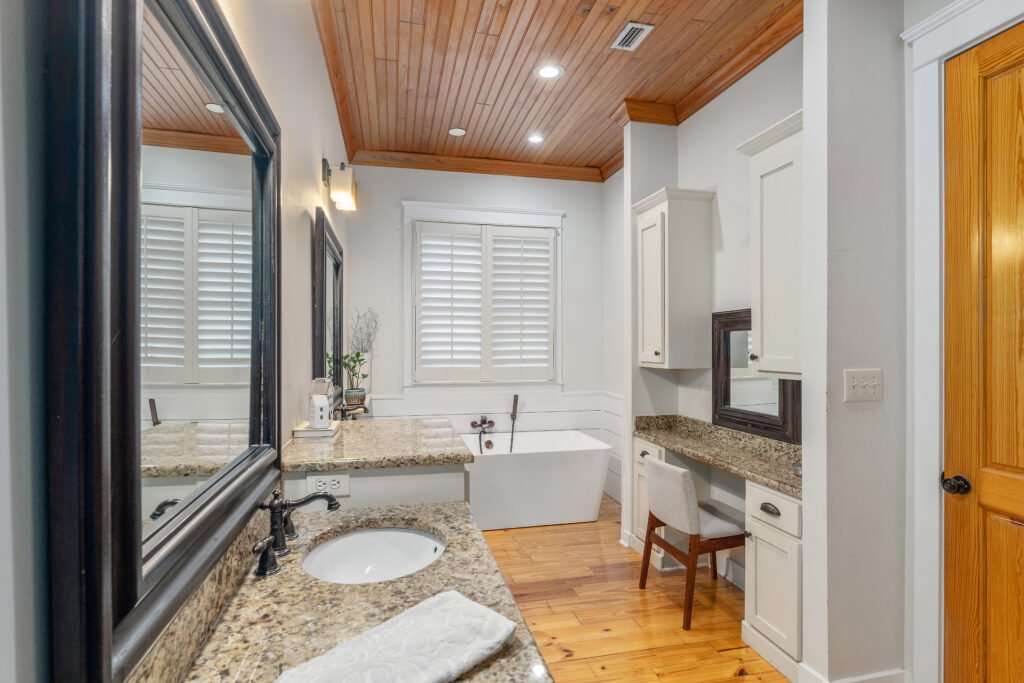 Bay house theme continues in master bath with wood shiplap ceilings above "his and hers" split vanity.