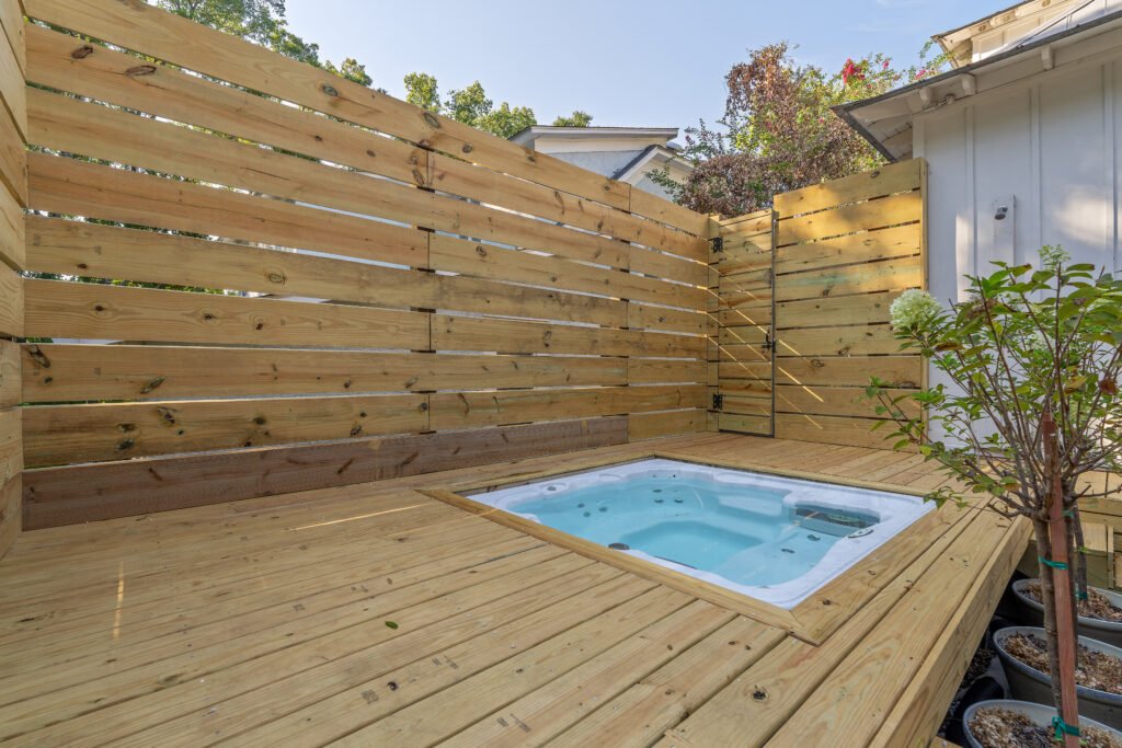 Close up of hot tub in wood deck in back yard.