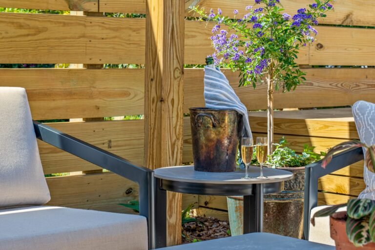 Seating area framed by Duranta tree and flower pots at Emerson House