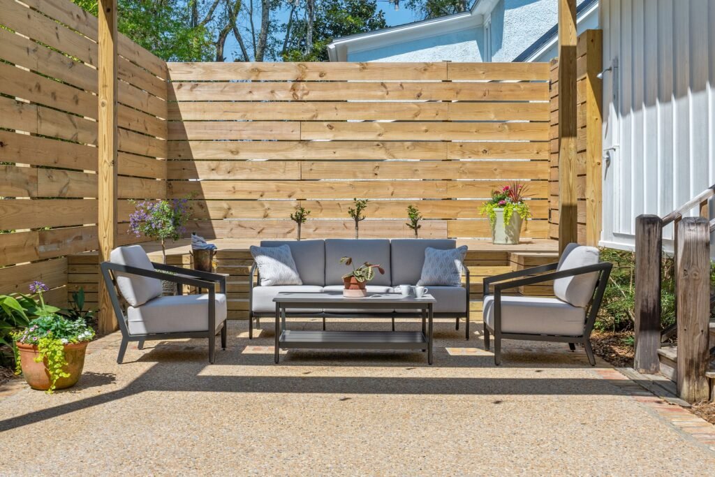 Patio loveseat and coffee table with potted flowers at Emerson House