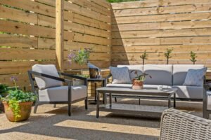 Patio seating area with cushioned furniture and container gardens at Emerson House