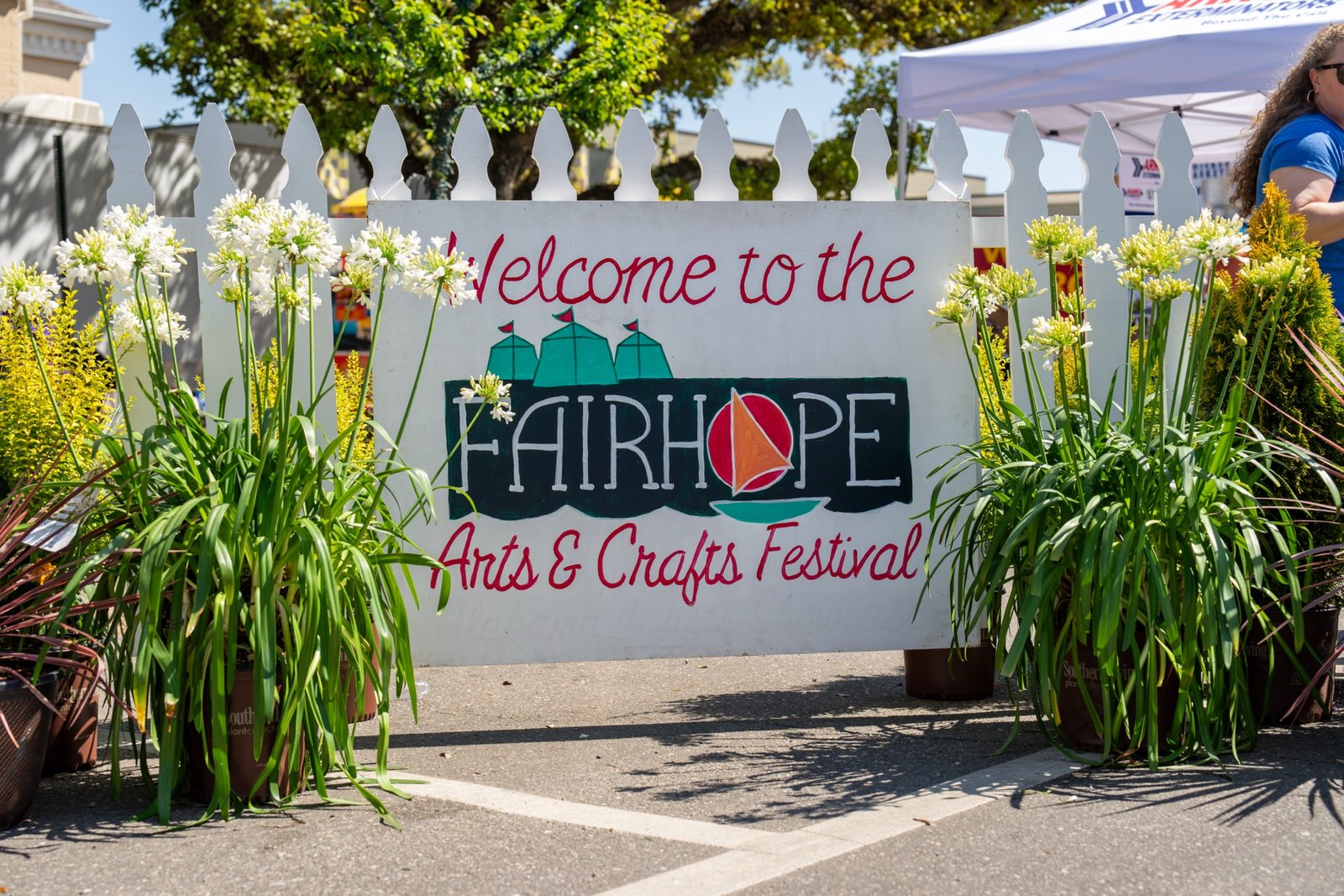 Welcome to Fairhope Arts and Crafts Festival sign between potted white Agapanthus